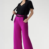 Designed for versatility, it features a soft tie neckline that can be worn loose and relaxed, gently draped, or fastened high for a more polished, elevated look. Short sleeves are subtly gathered at the shoulder and finished with a refined split, offering elegant movement and light coverage without compromising comfort.