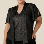 A plus size, size 18 woman wears a good top for curvy women's evening and event wear. In shimmering bronze foil print, this V-neck top with short flutter sleeves is made in Australia by women's fashion brand, Leina and Fleur.