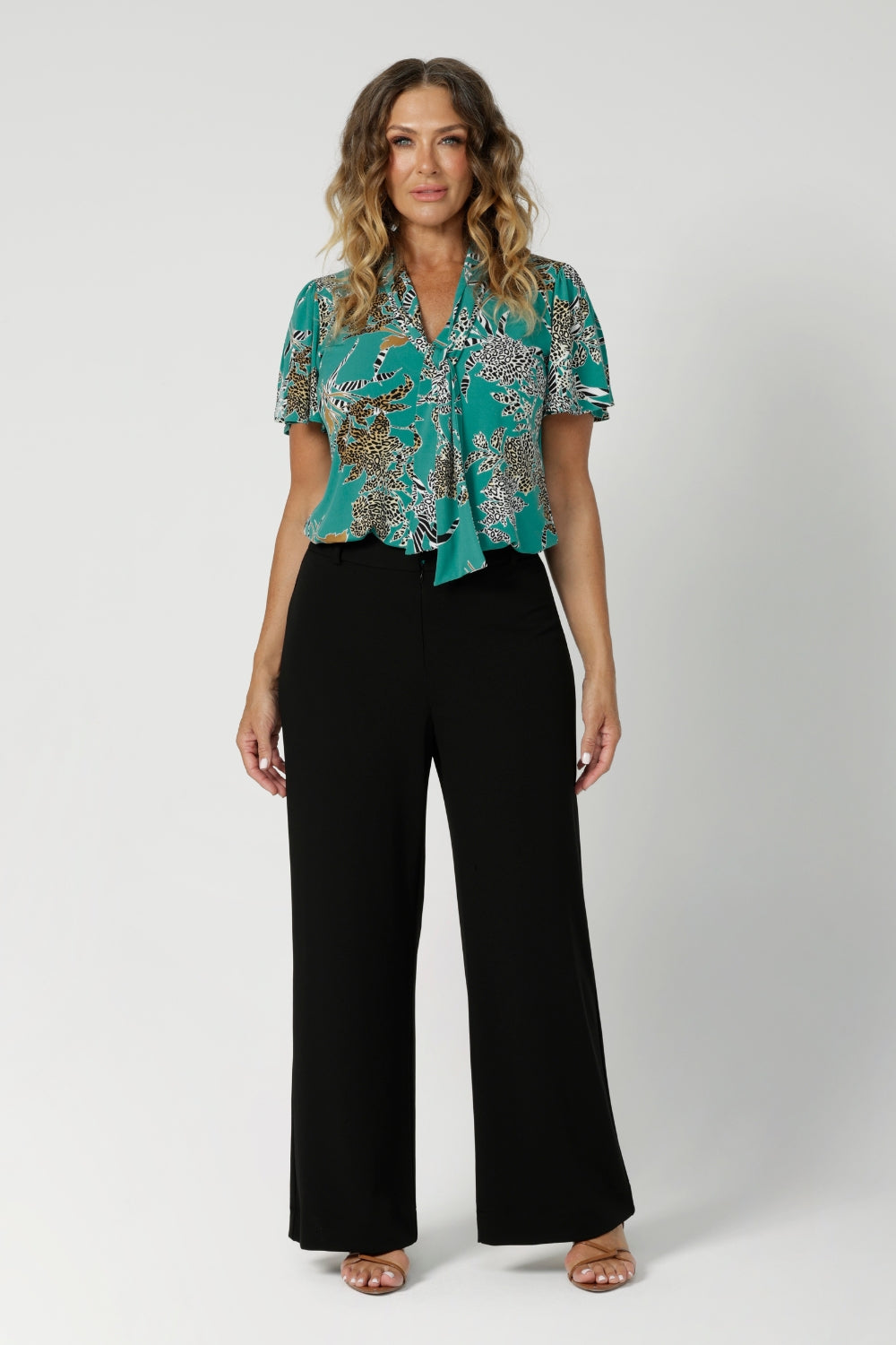 Size 12 model wears short sleeved top paired with black workwear pants. Jade safari collection for the woman on the go. This shirt transitions effortlessly from work to after-hours events, offering both style and functionality. Proudly made in Australia, designed with Australian and New Zealand women in mind, and stocked in a wide range of sizes from 8 to 24 to ensure a perfect fit for every women.