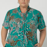 This short-sleeved top features a flattering cut and a unique neckline with tie details. The neck ties can be done up for added coverage or left undone for a more relaxed, open look, allowing you to customise the shirt to your comfort and style preferences. The sleeve features a slit detail that ads a soft feminine look to your ideal back to work piece. Available in sizes 8-24.