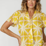 This short-sleeved top features a flattering cut and a unique neckline with tie details. The neck ties can be done up for added coverage or left undone for a more relaxed, open look, allowing you to customise the shirt to your comfort and style preferences. The sleeve features a slit detail that ads a soft feminine look to your ideal back to work piece. Available in sizes 8-24.