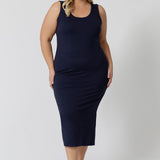 A midi dress that works as a nightdress and as loungewear. Shown on a size 18 woman, this slim-fit, plus size midi-dress in navy blue bamboo jersey is breathable and thermo-regulating. A good dress for night sweats and hot flushes, wear this as a summer dress for warm summer days. Shop nightdresses in women's clothes brand, L&F's new loungewear and sleepwear range online in sizes 8 to 24.