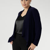 Woman wearing a navy blue cardigan over a black satin cami and skinny leg pans by Leina + Fleur. Softly tailored with a refined waterfall collar and an open front design, Mikey offers a polished, jacket-like silhouette that effortlessly carries you from the workday into evening events. 