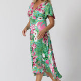 40 year old woman wears floral midi dress with twist bodice, flutter sleeve and high-low hem. This floral dress is made of slinky jersey making it perfect for beachside resorts, casual summer outings or easy resort style. Made in Australia by fashion brand Leina & Fleur stocked in sizes 8-24. 