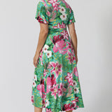 Back view of Milly Dress in Malibu detailing high-low hem and flutter sleeve. Midi length dress is made of floral slinky jersey fabric. Easy care dress is perfect for travel due to its wrinkle resistant features. Leina & Fleur proudly stocks sizes 8-24 including plus & petite friendly styles.