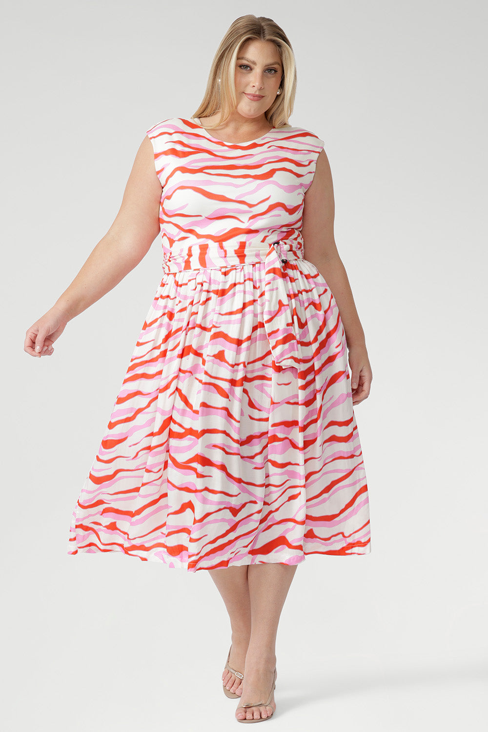 The vibrant abstract print combines pink and red tones on a soft vanilla base, bringing playful energy to warm days. Finished with a coordinating belt to define the waist. Made in Australia with integrity.