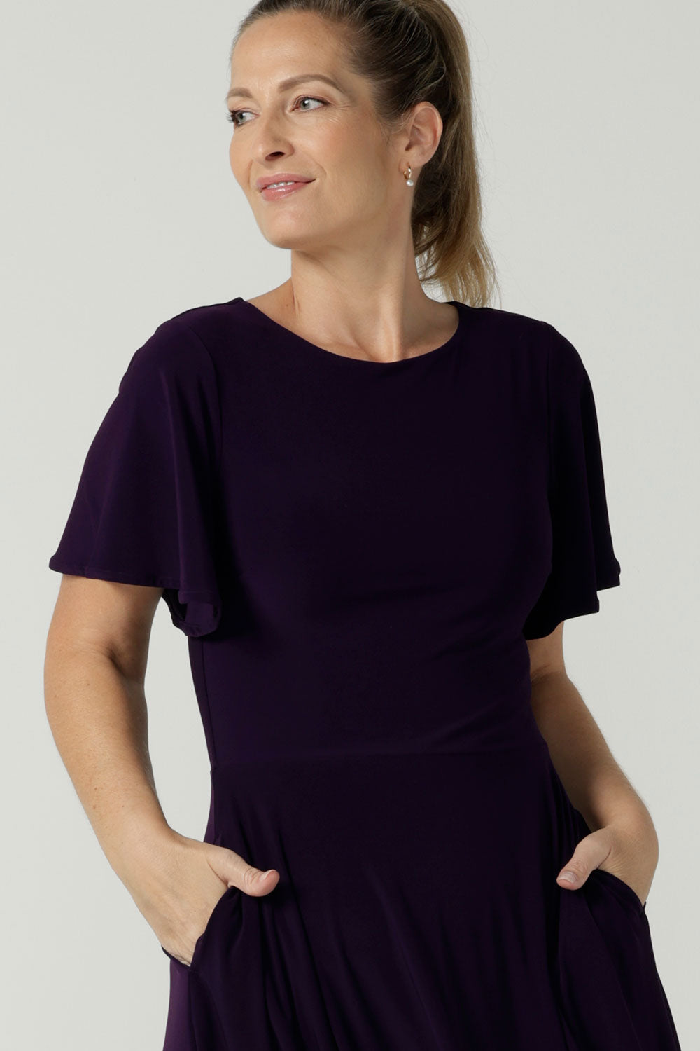 Close up of the Monique dress in Amethyst. Jersey dress with flutter sleeve and rounded neckline. Full circle skirt and pockets. Made in Australia for women size 8 - 24.