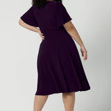 Back view of a Monique dress in Amethyst. Jersey dress with flutter sleeve and rounded neckline. Full circle skirt and pockets. Made in Australia for women size 8 - 24.