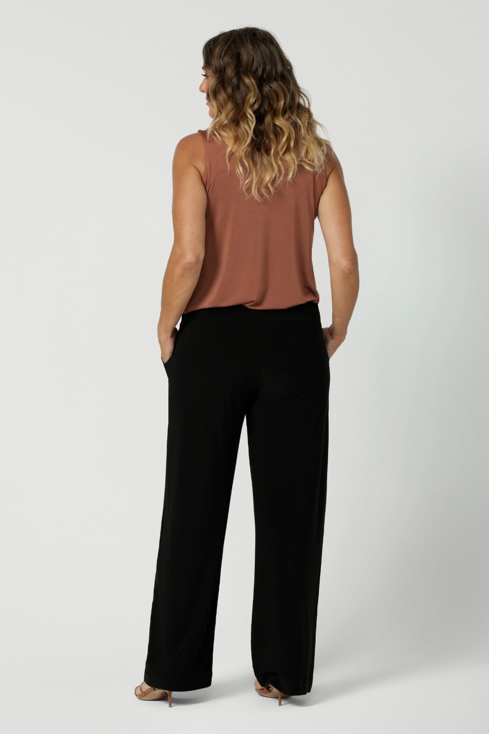 Back image of size 12 model in her 40's wearing back to work black pants. Monroe  Pants feature a pull on easy style, with a full length straight leg. Made with easy care, heavy weight, dry touch jersey fabric in Australia for the woman on the go. Shop Leina & Fleur core products in a variety of sizes from 8-24. The Monroe Pant now is available in 3 heights.