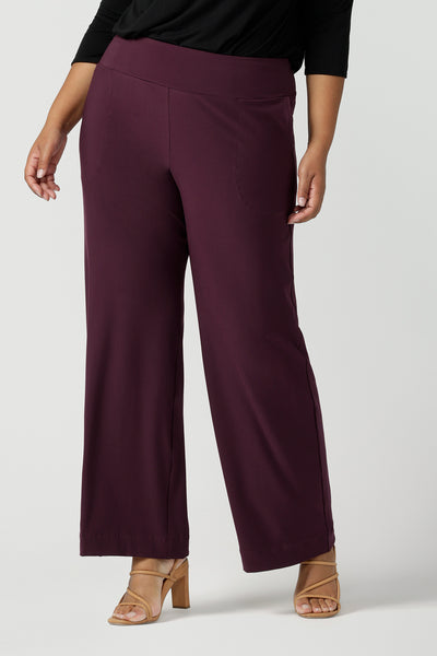 A close up of an Australian-made wide leg, full length jersey trouser in Mulberry red. By Australian and New Zealand fashion label, L&F these straight-cut work pants promise to be a comfortable corporate trouser for sizes 8 to size 24.
