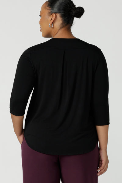 Back view of a black bamboo pleat front top on a size 18 curvy woman. With a 3/4 sleeve and high-low hem, this top is a great women’s work top for corporate wear.  Styled back with a mulberry workwear corporate pant tube skirt. Designed and made in Australia for women sizes 8 - 24. Leina and Fleur. 