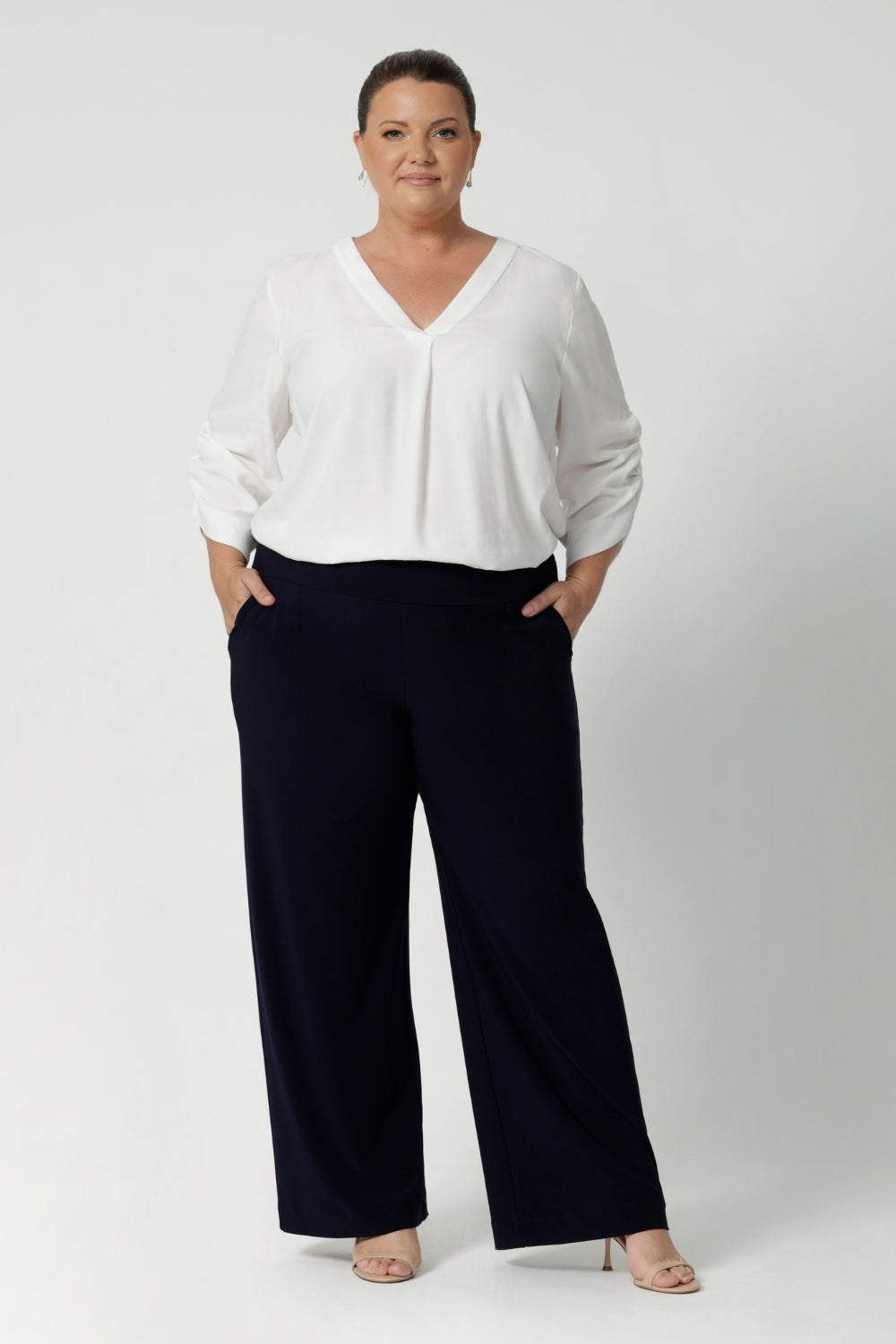 Women's size inclusive work pants. Pictured on a size 18 woman, these comfortable navy corporate pants. Full length navy, straight leg pants with stretch. Shop in sizes 8-24.