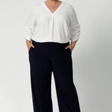 Women's size inclusive work pants. Pictured on a size 18 woman, these comfortable navy corporate pants. Full length navy, straight leg pants with stretch. Shop in sizes 8-24.