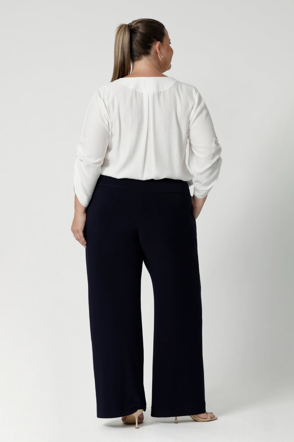 Back view image of Women's size inclusive work pants. Pictured on a size 18 woman, these comfortable navy corporate pants. Full length navy, straight leg pants with stretch. Shop in sizes 8-24. 