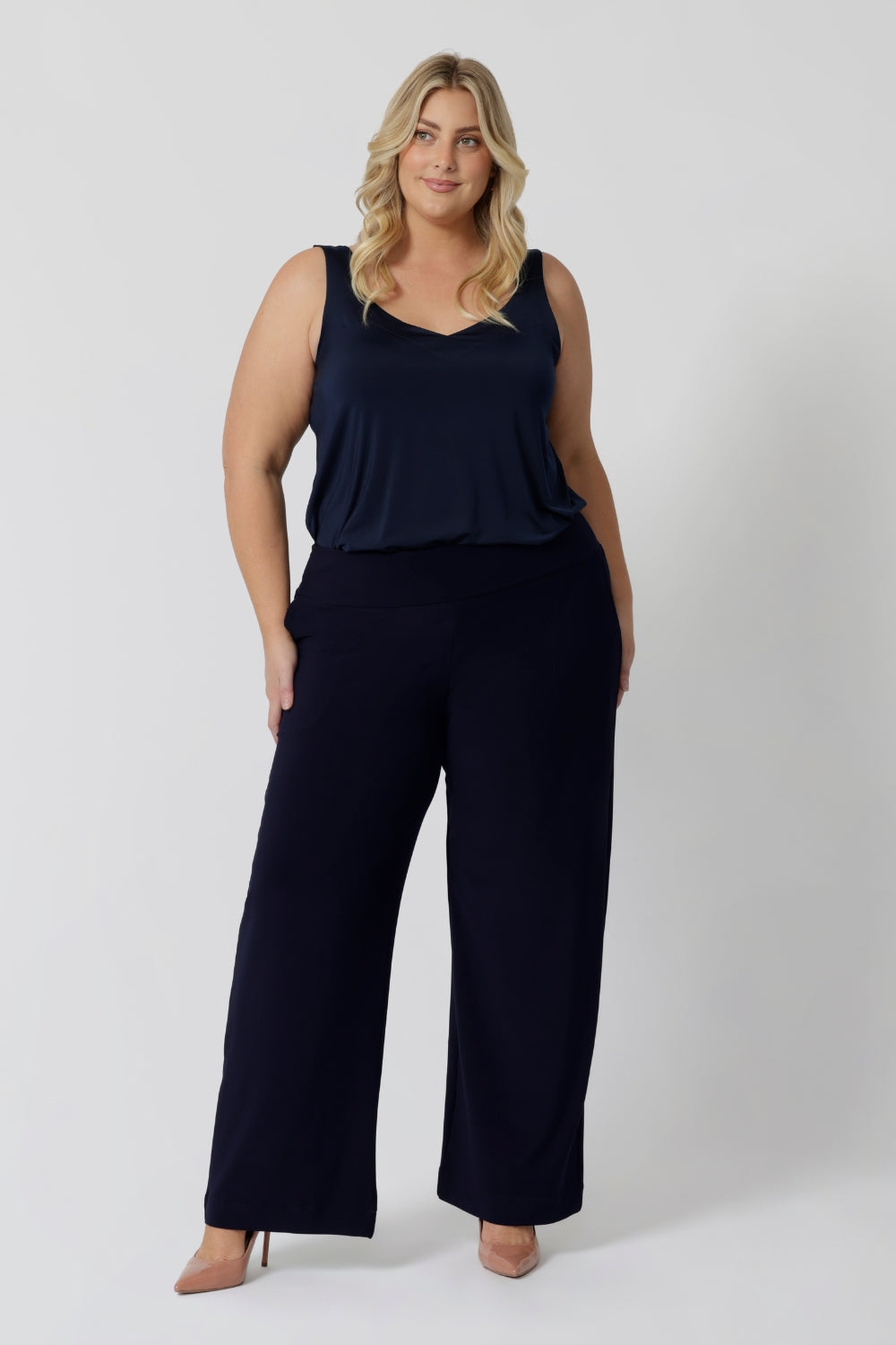 Full length, navy pants worn by plus size woman. Ideal for the woman on the go. Providing a great edition to any corporate wardrobe. Made with dry touch jersey fabric in Australia by fashion brand Leina & Fleur. Shop now in sizes 8-24 and with 3 length options. 