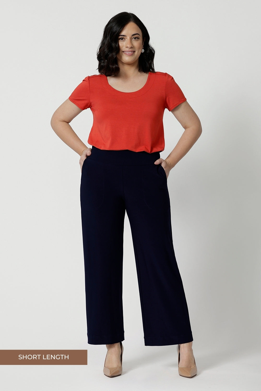 Navy workwear pants worn by size 10 model. Made with easy care, dry touch jersey fabric that provides long lasting quality and comfort. Available in sizes 8-24, with 3 height length options. Model wears short height Monroe Pants