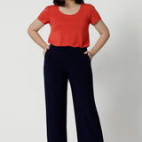 Navy workwear pants worn by size 10 model. Made with easy care, dry touch jersey fabric that provides long lasting quality and comfort. Available in sizes 8-24, with 3 height length options. Model wears short height Monroe Pants