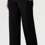 Close up image of black, stretchy workwear pant. Whether you're heading to the office or a professional event, the Monroe Pant ensures you look polished and feel at ease. Plus size woman wears her Monroe pants with brown kitten heel and straight hem top.