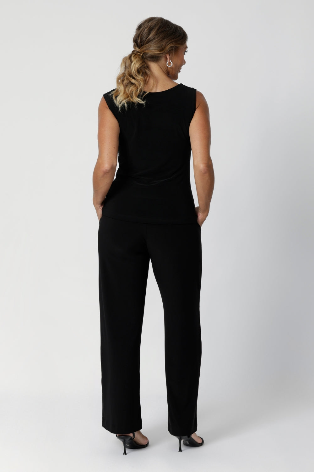 Back image of size 12 model in her 40's wearing back to work black pants. Monroe  Pants feature a pull on easy style, with a full length straight leg. Made with easy care, heavy weight, dry touch jersey fabric in Australia for the woman on the go. Shop Leina & Fleur core products in a variety of sizes from 8-24. The Monroe Pant now is available in 3 heights.