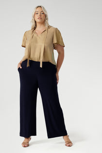 Women's size inclusive work pants. Pictured on a size 18 woman, these comfortable navy corporate pants. Full length navy, straight leg pants with stretch. Shop in sizes 8-24.