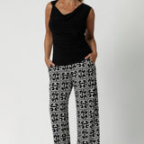 Made in Australia, the Monroe Pant combines versatility and sophistication, making them perfect for transitioning seamlessly from work to weekend. Over 40's woman wears printed pants with black workwear top and black heels.