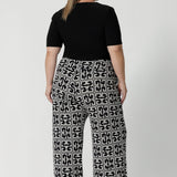 Back view image of size 18 woman wearing geometric printed workwear pants with black elbow length top and heels - curating an easy wear corporate look. Shop the Monroe Pant range in sizes 8-24.