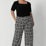 The Monroe Pant is designed to cater to various heights and comes in sizes 8-24, with the option of 3 pant lengths ensuring a great fit for all body types. Plus size woman wears regular length Monroe Pants with black top and heels.