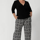 Size 18 model wears long length Monroe Pants in Olympia print with black fixed wrap top and black heels, creating an outfit that is perfect for the corporate woman on the go. Available in sizes 8-24, with the option of 3 pant lengths. 