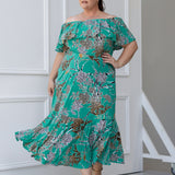  Plus sized woman wears the Myla dress in Jade Safari off the shoulders - a jade coloured dress with abstract animal print design. Maxi dress features side pockets and frill hem. Made in Australia and size inclusive for women size 8-24. 