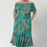 Plus sized woman wears Australia Made maxi dress in jade colour. Frill bodice and frill skirt dress adds fluid and feminine movement for off duty weekend statement styling. Shop jade safari collection at Leina & Fleur in size 8-24.