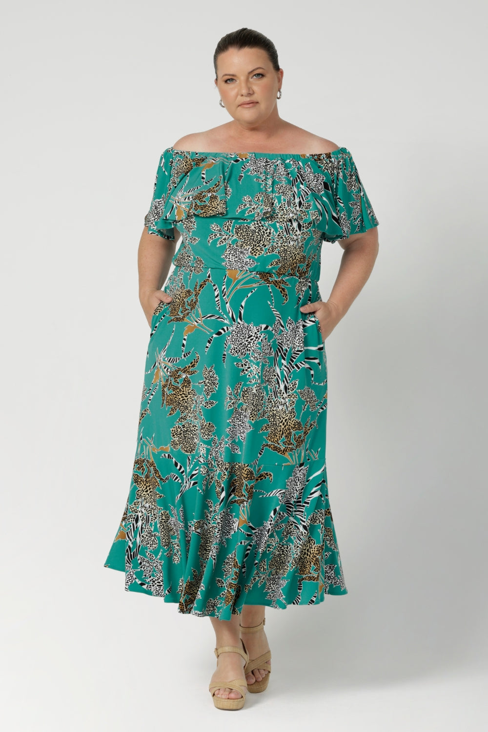 Plus sized woman wears Australia Made maxi dress in jade colour. Frill bodice and frill skirt dress adds fluid and feminine movement for off duty weekend statement styling. Shop jade safari collection at Leina & Fleur in size 8-24.