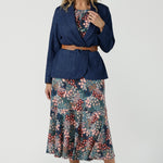 Worn on one shoulder. A woman wears the Myla dress in Whimsy an off shoulder frill neck style. Side pockets and frill hem. Made in Australia and size inclusive for women size 8-24. Styled back with a Denim Blazer.