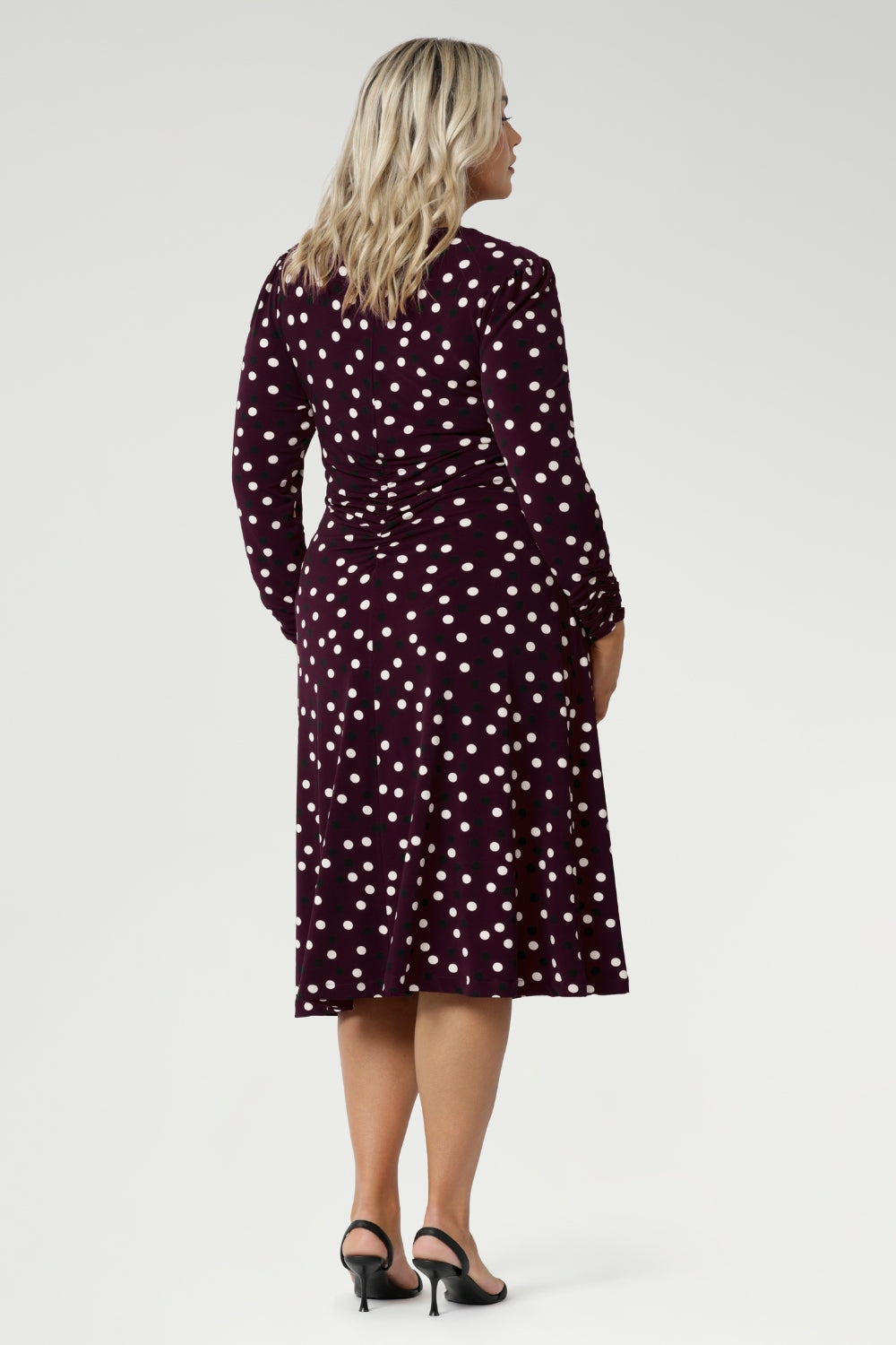 Crafted from high-quality Australian-made jersey fabric, this below-the-knee dress showcases a rich deep burgundy base adorned with a timeless black and white polka dot print, making it a stylish and sophisticated option for the office or any smart-casual occasion.