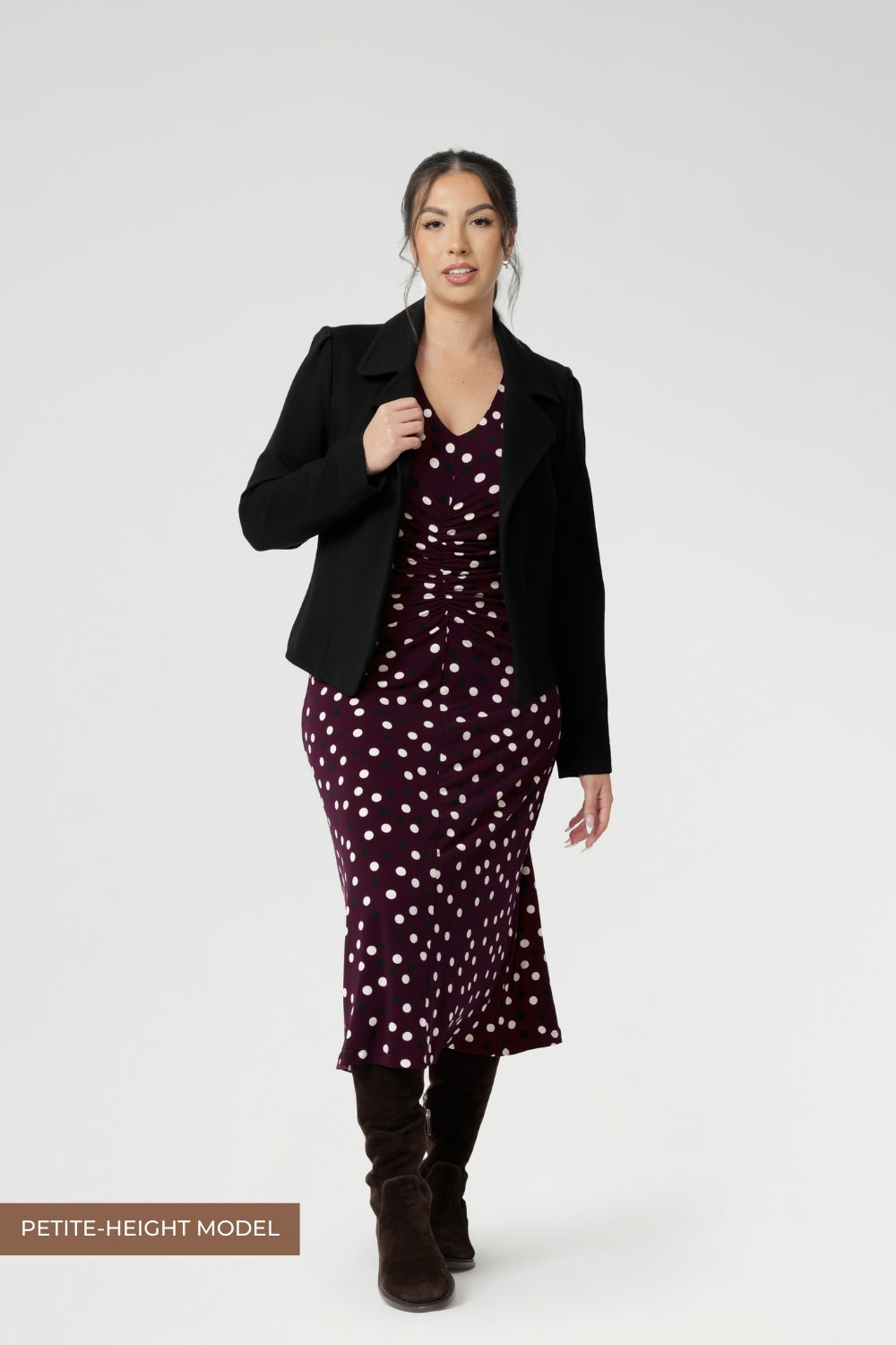 Petite height woman wears workwear dress with thoughtfully placed ruched details at the front, back, and along the sleeves. Which ad gentle shaping and a touch of textural interest, while enhancing comfort and ease of movement.