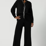 A size 10 woman wears the Silver Neck tie Silver Sequin Ellis and made in Australia size 8-24, Styled back with a shirt in black and black scuba crepe pants.