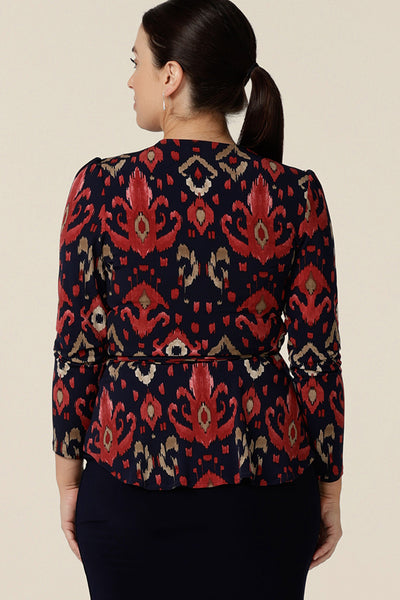 Back view of a long sleeve wrap top in Ikat print jersey is worn by a size 10 woman. Great for workwear and fashionable mum-style, this top is elegant and easy-care. The Noah Top is made in Australia by Australian and New Zealand women's clothing label, Leina and Fleur.