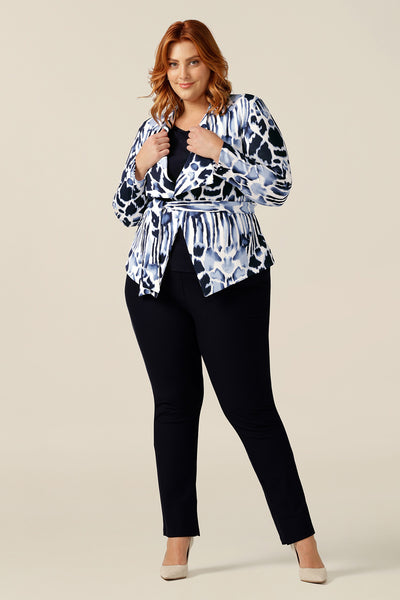 a size 18 woman wears a wrap-front navy and white jacket with skinny cropped navy pants and a navy jersey top as part of a stylist guide on how to shop colour and print for corporate and work wear jacekts.