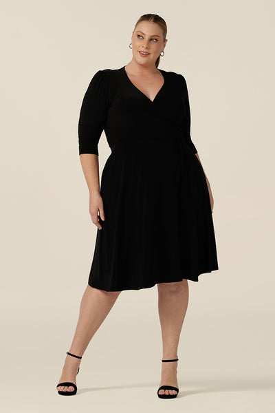 A knee length wrap dress in black jersey looks elegant for evening and occasionwear. Shown for plus sizes, this 3/4 sleeve event dress is made in Australia in dress sizes 8 to 24.
