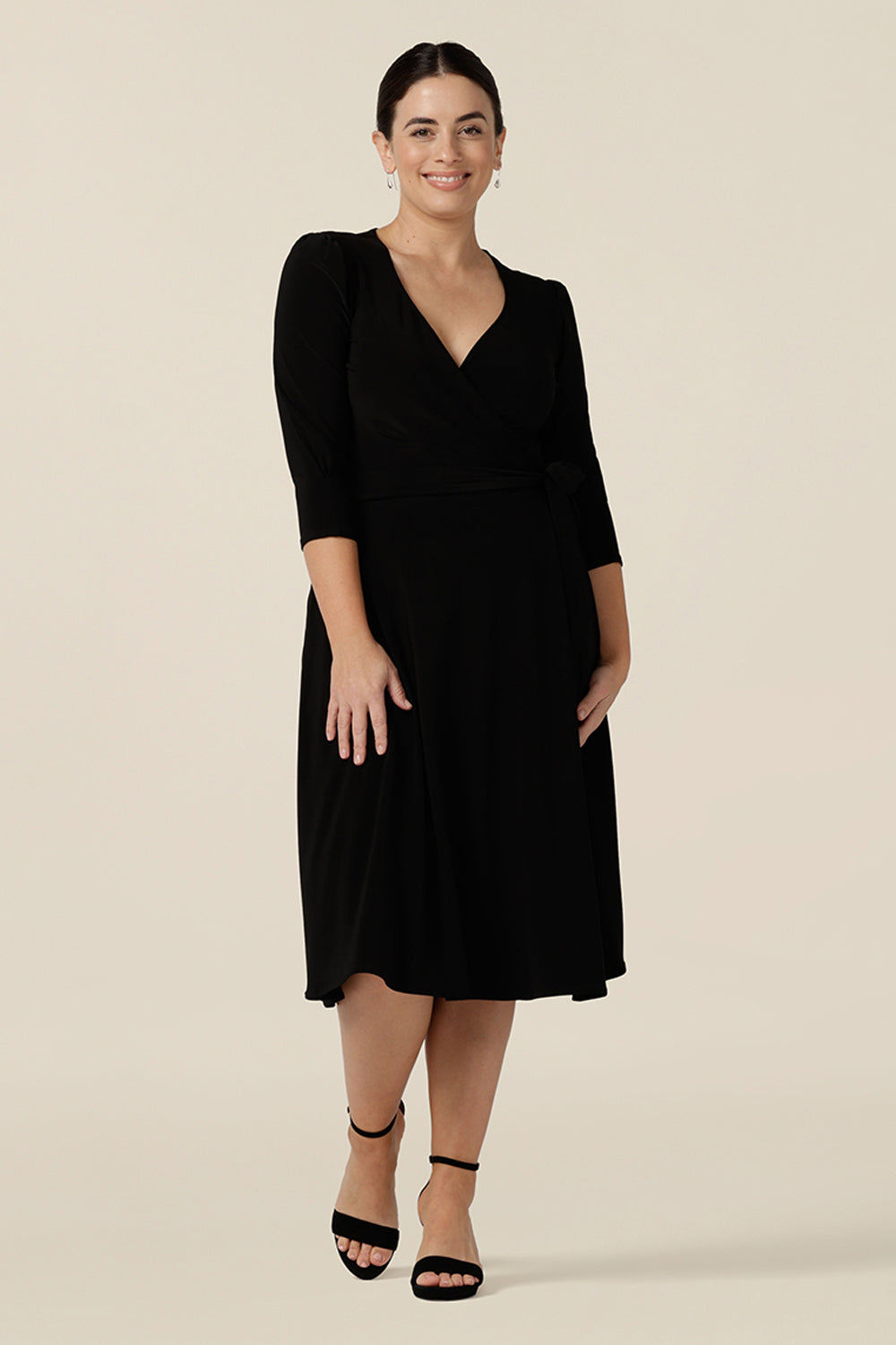 A knee length wrap dress in black jersey looks elegant for evening and occasion wear. Shown in size 10, this 3/4 sleeve classic event dress is made in Australia in dress sizes 8 to 24.