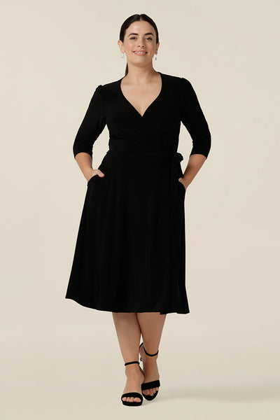 A knee length wrap dress in black jersey looks elegant for evening and occasion wear, shown in size 10. Shown in size 10, this 3/4 sleeve smart casual dress is made in Australia in dress sizes 8 to 24.