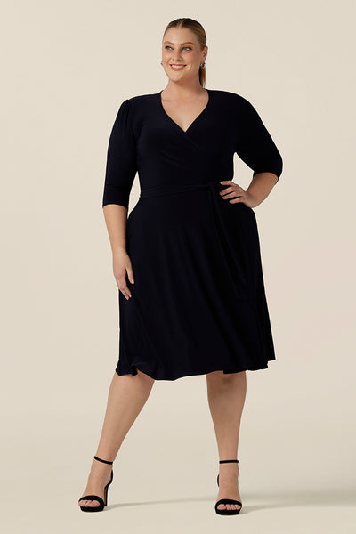A classic knee length wrap dress in navy blue jersey looks elegant for evening and occasion wear. Shown for plus sizes, this 3/4 sleeve event dress is made in Australia in dress sizes 8 to 24.