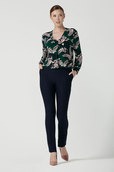 A size 10 woman wears the Paeton Top in Alpine Fern. Styled back with the Diaz Pant in Navy. A wide leg pant in black styled back with boots. Made in Australia for women size 8 - 24.