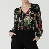 A size 10 woman wears a jersey work top called the Paeton in Bloomsbury print. Long sleeves with cuff detailed and made in Australia for women size 8-24