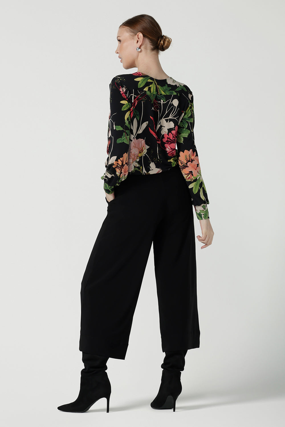 Back view of a size 10 woman wears a jersey work top called the Paeton in Bloomsbury print. Long sleeves with cuff detailed and made in Australia for women size 8-24. Styled back with slim fit comfortable work pants  Bradley culottes.