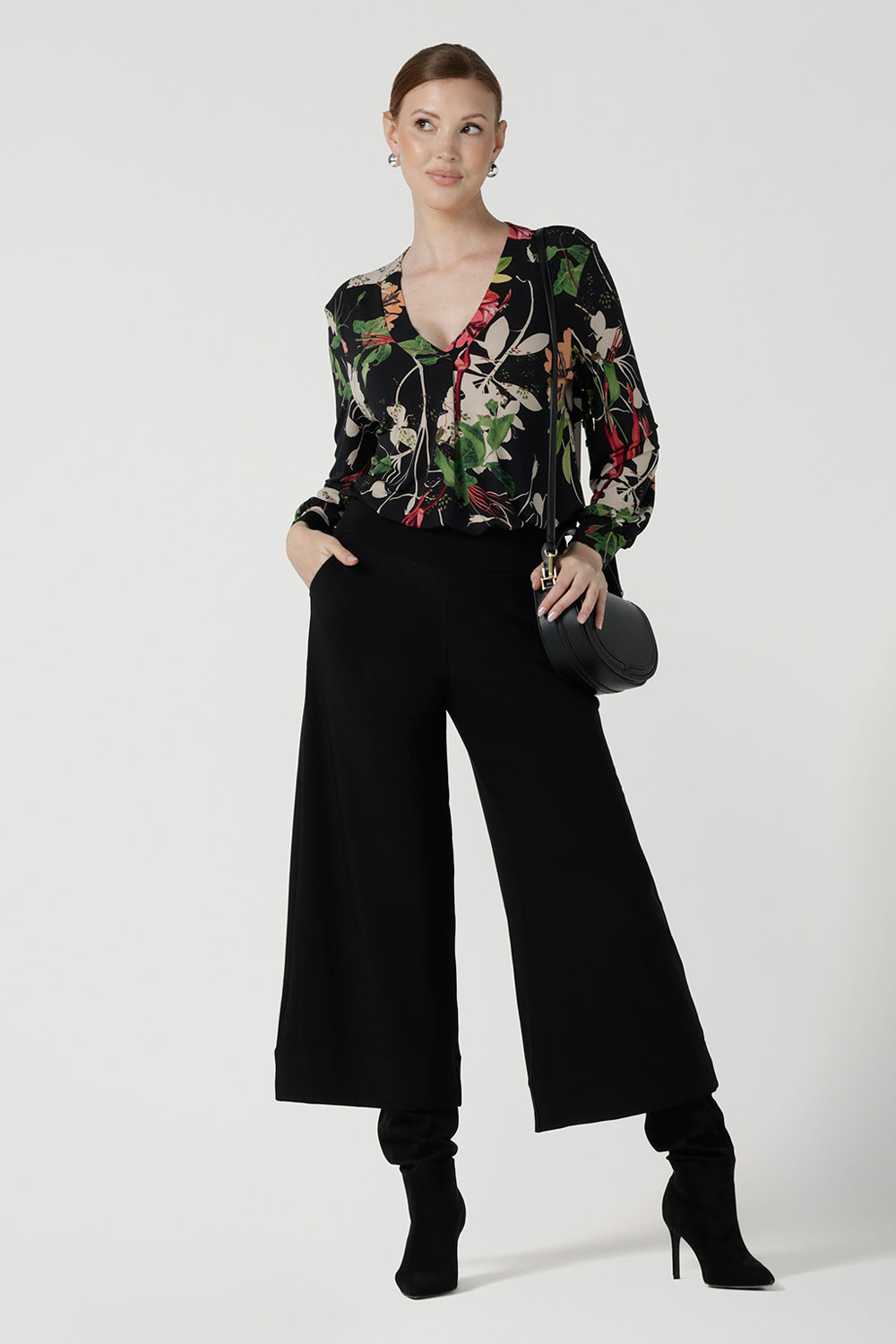 Front view of a size 10 woman wears a jersey work top called the Paeton in Bloomsbury print. Long sleeves with cuff detailed and made in Australia for women size 8-24. Styled back with slim fit comfortable work pants Bradley culottes.