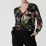 A size 10 woman wears a jersey work top called the Paeton in Bloomsbury print. Long sleeves with cuff detailed and made in Australia for women size 8-24