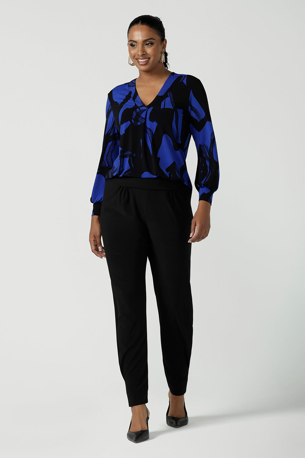 A size 10 woman wearing the Paeton Top in Kabuki. A jersey v-neck style top with cuffed sleeve. Made in Australia for women size 8-24. Easy care work top for petite to plus size women.