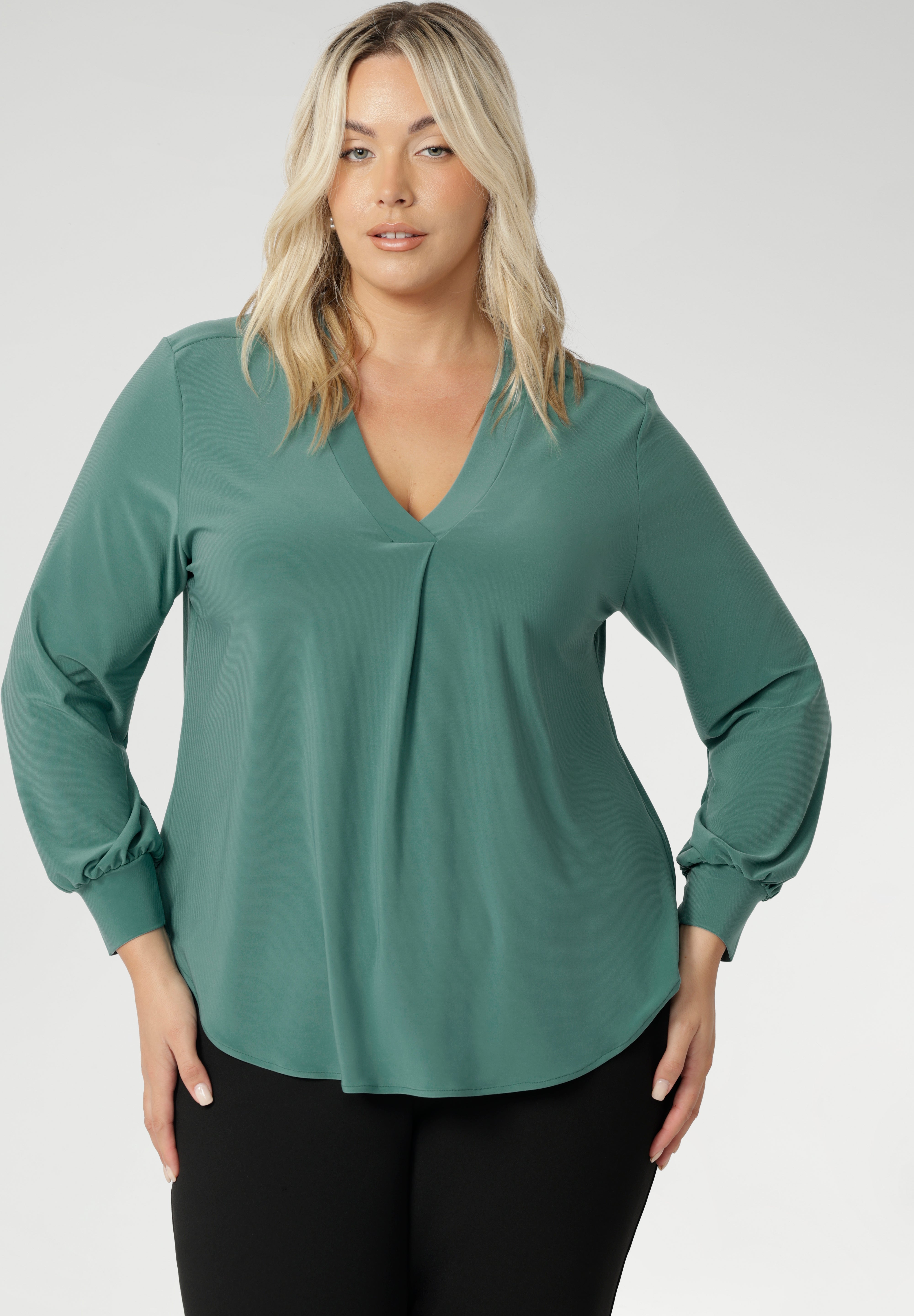 Designed with a relaxed fit that flatters all body types—petite to plus-size—you can easily size down for a more tailored silhouette. This chic top features a flattering V-neckline with a refined front tuck, long sleeves with cuffs, a shoulder yoke, and a centre-back tuck for subtle structure. Size 18 model wears her Paeton Top with black work pants. 