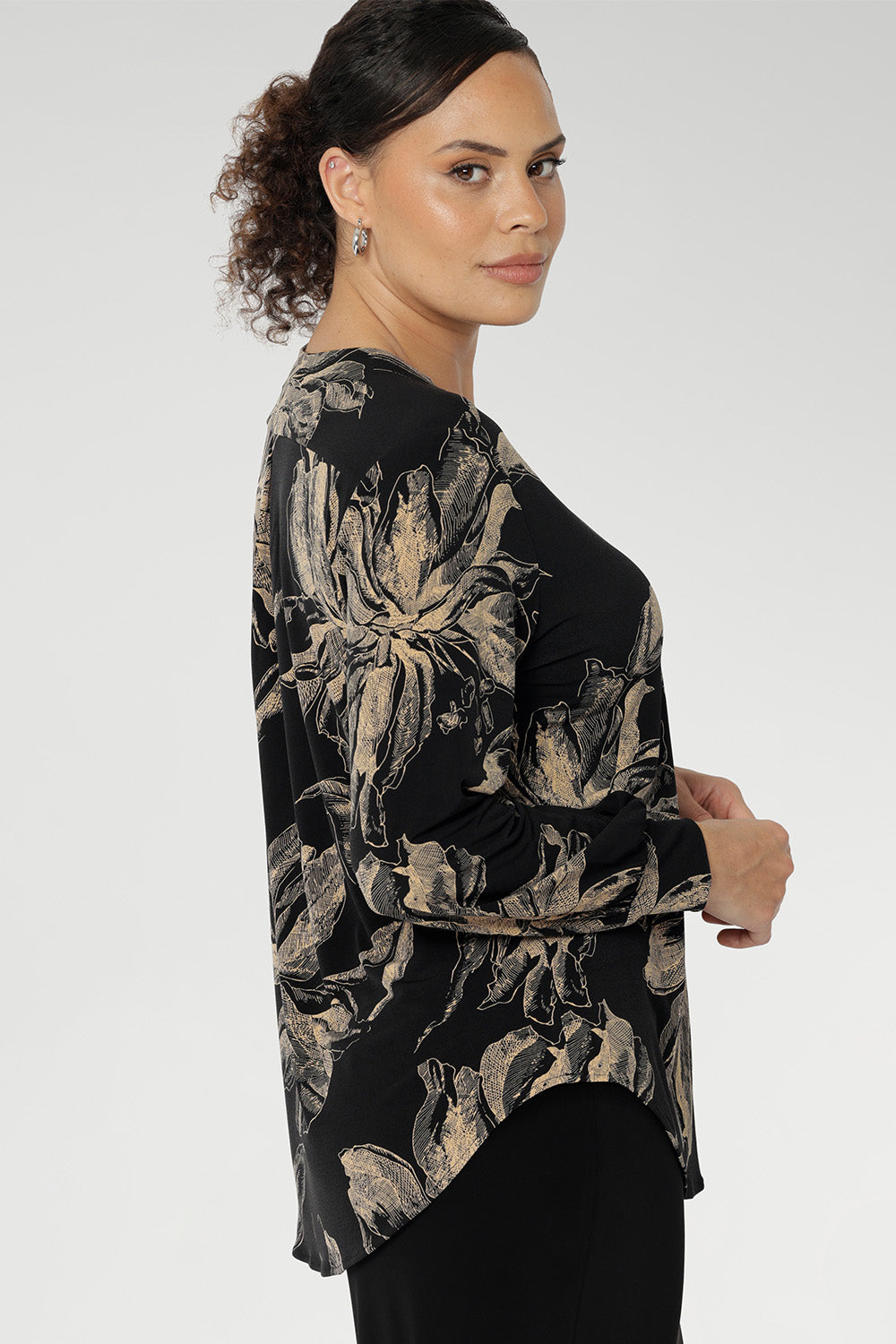 Paeton features refined design details such as the V-neckline with a tailored front tuck, long sleeves with cuffs, a structured shoulder yoke, and a curved shirttail hem.