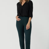 A size 10 woman wears the Paxton Pant for travel wear. Made in Ponte jersey and made in Australia for women size 8-24. Comfortable workwear for women, size inclusive fashion label Leina & Fleur. Styled back with the Ellis Shirt in Black Tencel